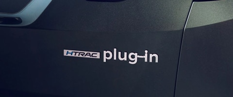 Close-up of a car featuring "HTRAC plug-in" emblem on a dark exterior.