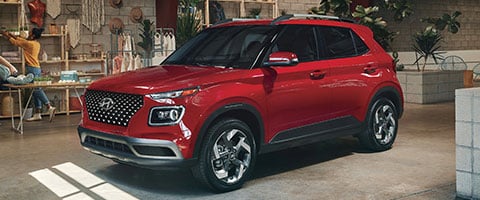 Red SUV parked indoors with houseplants and decor, showcasing modern design and style.