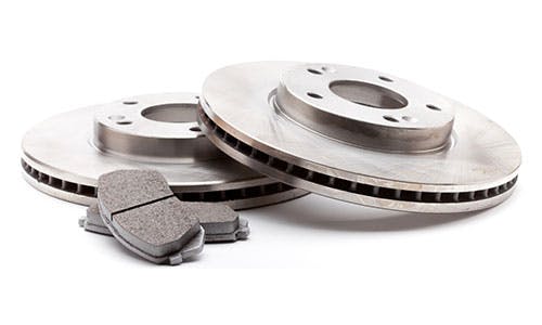 Two metallic brake discs and grey brake pads on a white background.