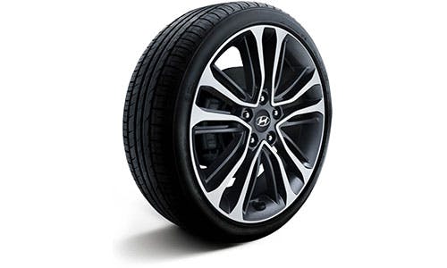 Silver and black alloy wheel with Hyundai logo on a tire, isolated on a white background.