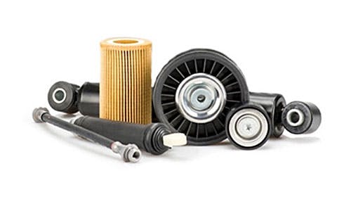 Assorted car parts including filters, pulleys, and bushings on a white background.
