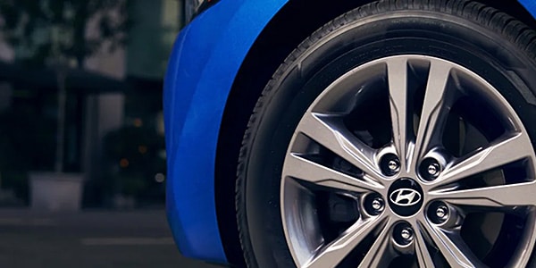 Close-up of a blue car wheel with a sleek alloy rim featuring the Hyundai logo.