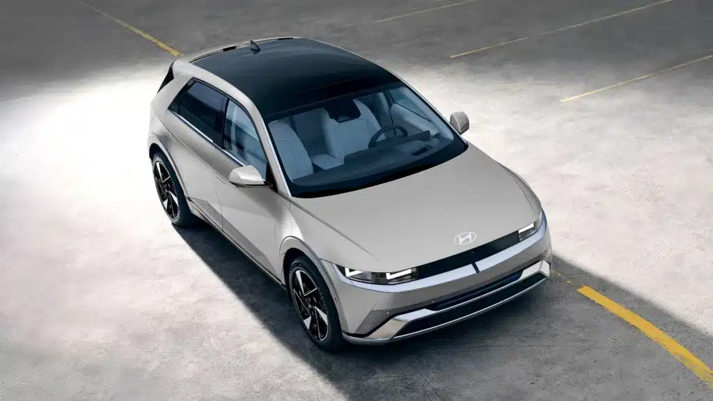 Silver Hyundai electric SUV parked in an empty lot, viewed from above.