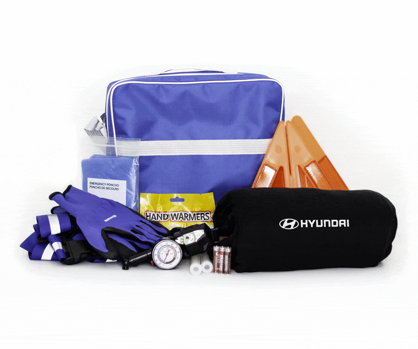 Emergency car kit with blue bag, gloves, poncho, hand warmers, blanket, and safety accessories.